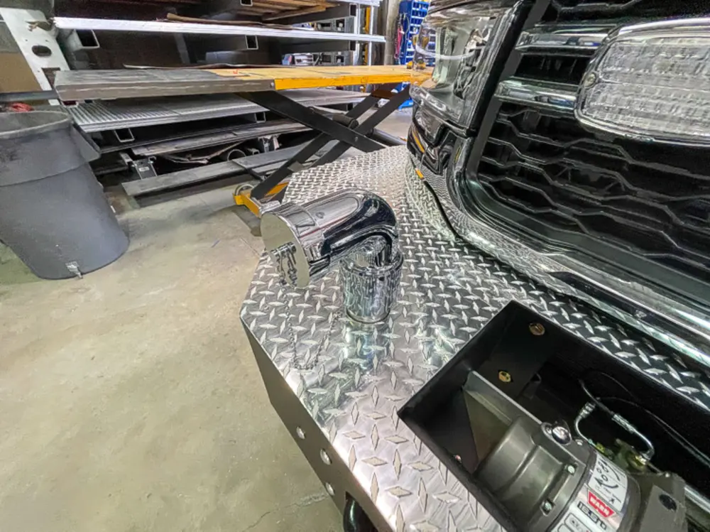 Exterior view of small fire truck showing cab, body compartments, and wheel/tire area.